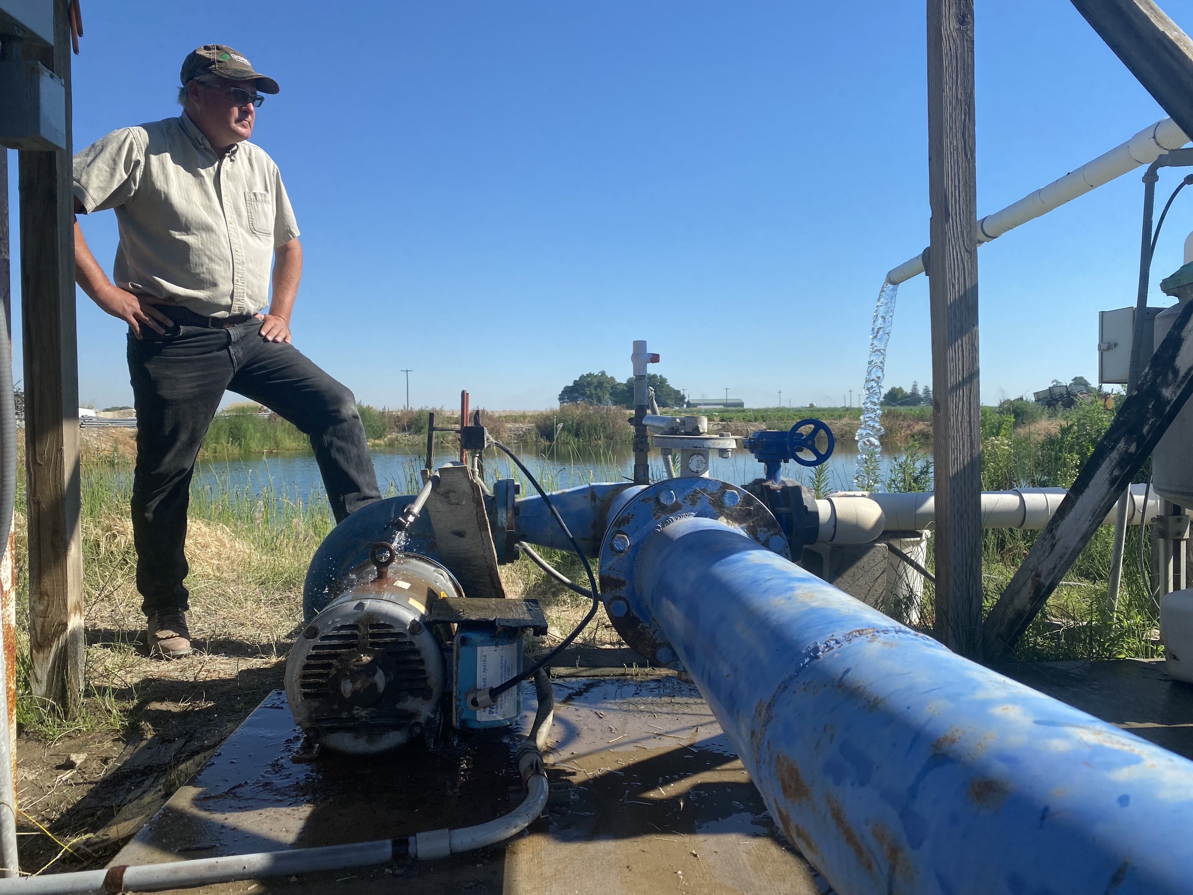 Alan Schreiber inspects his broken irrigation pump. It's only working at 30 percent capacity in 117 heat. CREDIT: Anna King/N3