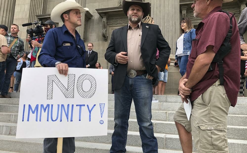 Ammon Bundy, center, who led the Malheur National Wildlife Refuge occupation, stands on the Idaho Statehouse steps in Boise. Mainstream and far-right Republicans are battling for control of the party and the state in deeply conservative Idaho. CREDIT: Keith Ridler/AP