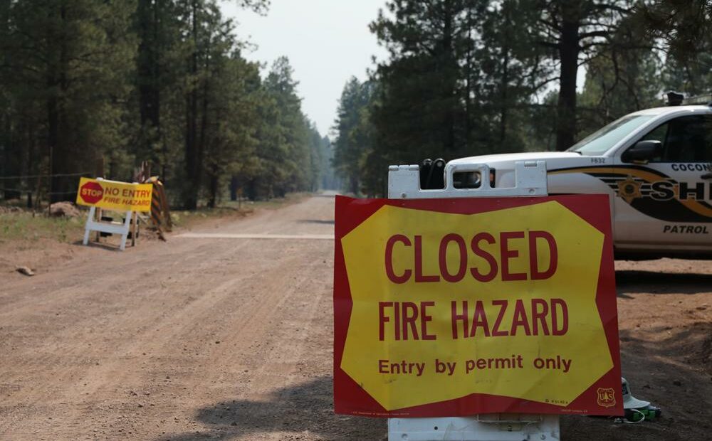 The Coconino County Sheriff's Office blocks off a U.S. Forest Service Road outside of Flagstaff, Ariz., on Monday, June 21, 2021. Dozens of wildfires were burning in hot, dry conditions across the U.S. West, including a blaze touched off by lightning that was moving toward northern Arizona's largest city. CREDIT: Brady Wheeler/Arizona Daily Sun via AP