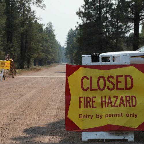The Coconino County Sheriff's Office blocks off a U.S. Forest Service Road outside of Flagstaff, Ariz., on Monday, June 21, 2021. Dozens of wildfires were burning in hot, dry conditions across the U.S. West, including a blaze touched off by lightning that was moving toward northern Arizona's largest city. CREDIT: Brady Wheeler/Arizona Daily Sun via AP
