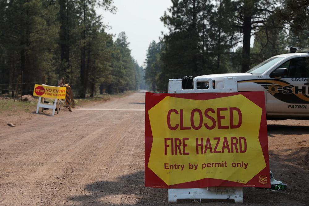 The Coconino County Sheriff's Office blocks off a U.S. Forest Service Road outside of Flagstaff, Ariz., on Monday, June 21, 2021. Dozens of wildfires were burning in hot, dry conditions across the U.S. West, including a blaze touched off by lightning that was moving toward northern Arizona's largest city. CREDIT: Brady Wheeler/Arizona Daily Sun via AP