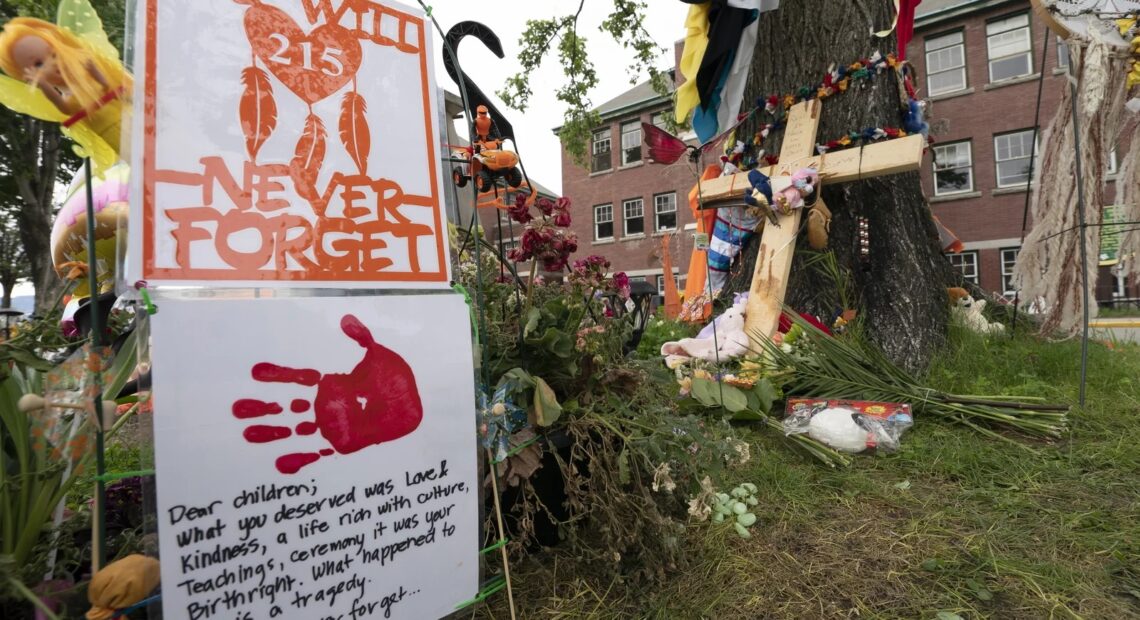 A memorial stands outside the Residential School in Kamloops, British Columbia. The remains of 215 children were discovered buried near the former Kamloops Indian Residential School earlier this month. Jonathan Hayward/The Canadian Press via AP