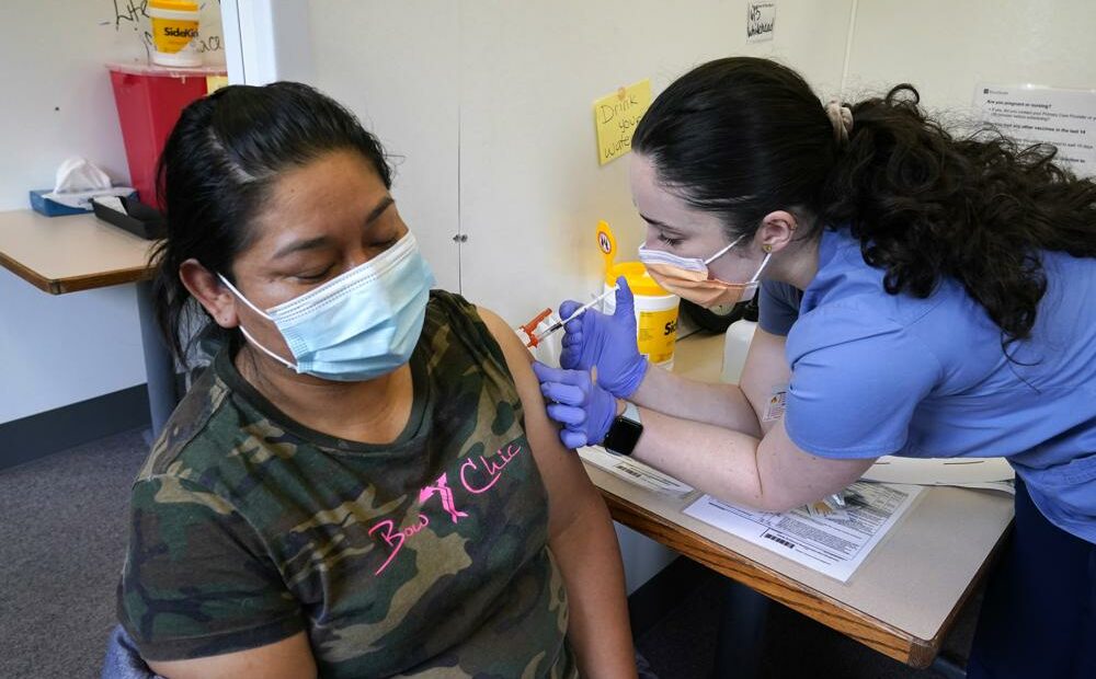 Medical assistant Andreea Marian, right, gives a COVID-19 vaccine to Gabina Morales at a clinic at PeaceHealth St. Joseph Medical Center Thursday, June 3, 2021, in Bellingham, Wash. Washington is the latest state to offer prizes to encourage people to get vaccinated against COVID-19, with Gov. Jay Inslee announcing a series of giveaways during the month of June that includes lottery drawings totaling $2 million, college tuition assistance, airline tickets and game systems. CREDIT: Elaine Thompson/AP