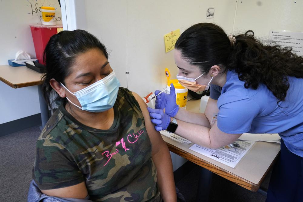 Medical assistant Andreea Marian, right, gives a COVID-19 vaccine to Gabina Morales at a clinic at PeaceHealth St. Joseph Medical Center Thursday, June 3, 2021, in Bellingham, Wash. Washington is the latest state to offer prizes to encourage people to get vaccinated against COVID-19, with Gov. Jay Inslee announcing a series of giveaways during the month of June that includes lottery drawings totaling $2 million, college tuition assistance, airline tickets and game systems. CREDIT: Elaine Thompson/AP