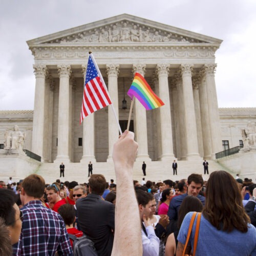 A man holds a U.S. and a rainbow flag outside the Supreme Court in Washington, D.C., on June 26, 2015, after the court legalized gay marriage nationwide. CREDIT: Jacquelyn Martin/AP