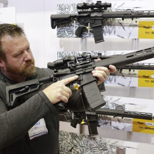 Bryan Oberc, in Munster, Ind., tries out an AR-15 from Sig Sauer in the exhibition hall at the National Rifle Association Annual Meeting in Indianapolis in 2019. CREDIT: Michael Conroy/AP