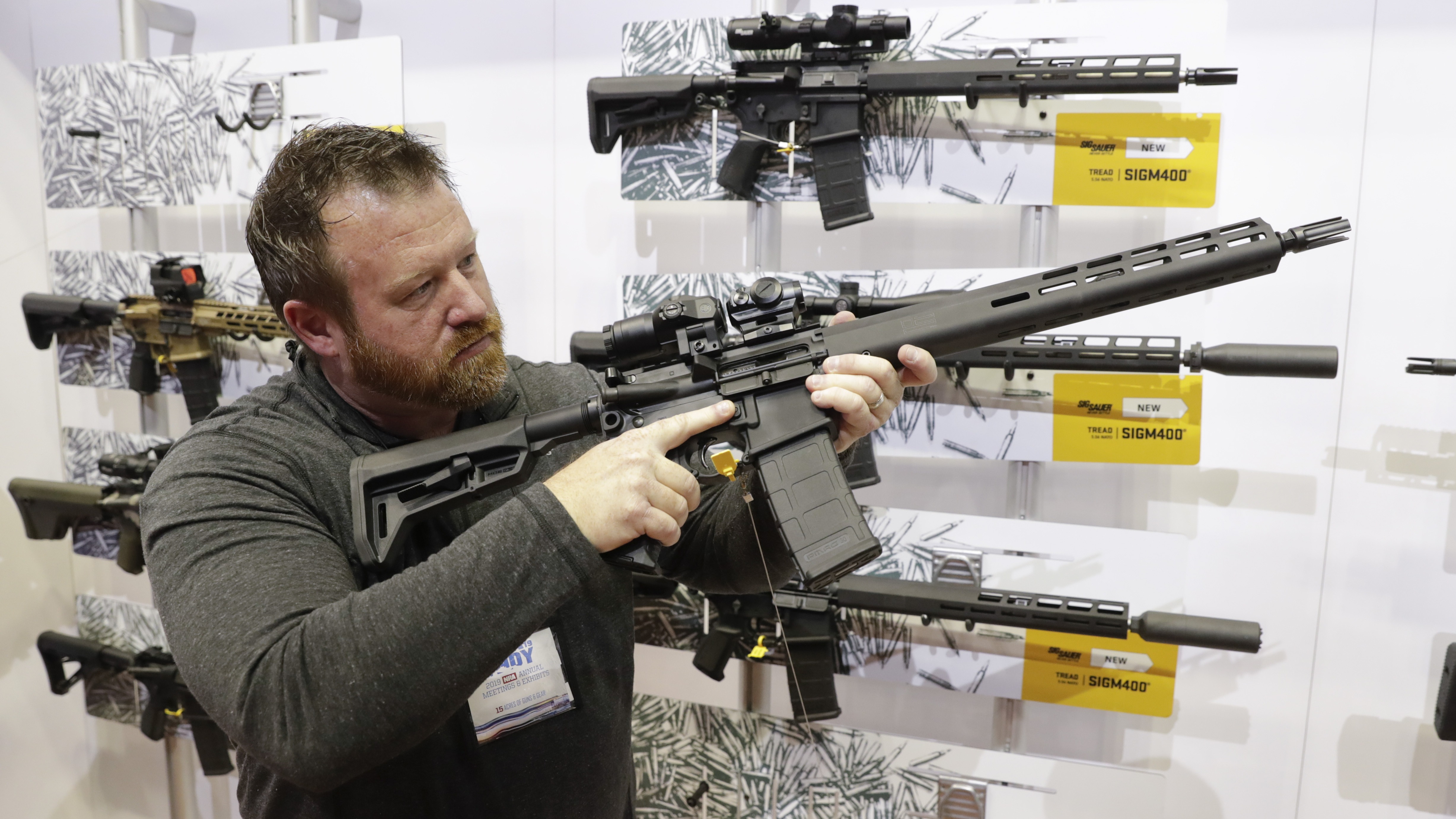 Bryan Oberc, in Munster, Ind., tries out an AR-15 from Sig Sauer in the exhibition hall at the National Rifle Association Annual Meeting in Indianapolis in 2019. CREDIT: Michael Conroy/AP