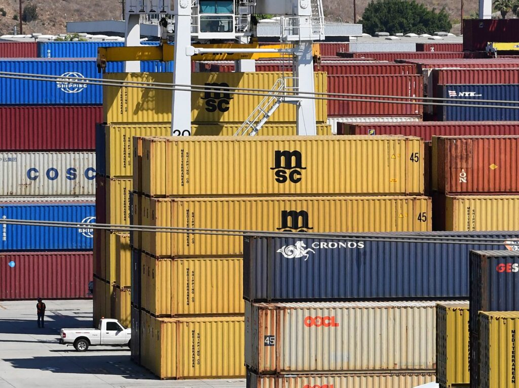 Shipping containers are stacked high at the Port of Los Angeles in April. Supply chain disruptions are hitting small-business owners across the United States. CREDIT: Frederic J. Brown/AFP via Getty Images