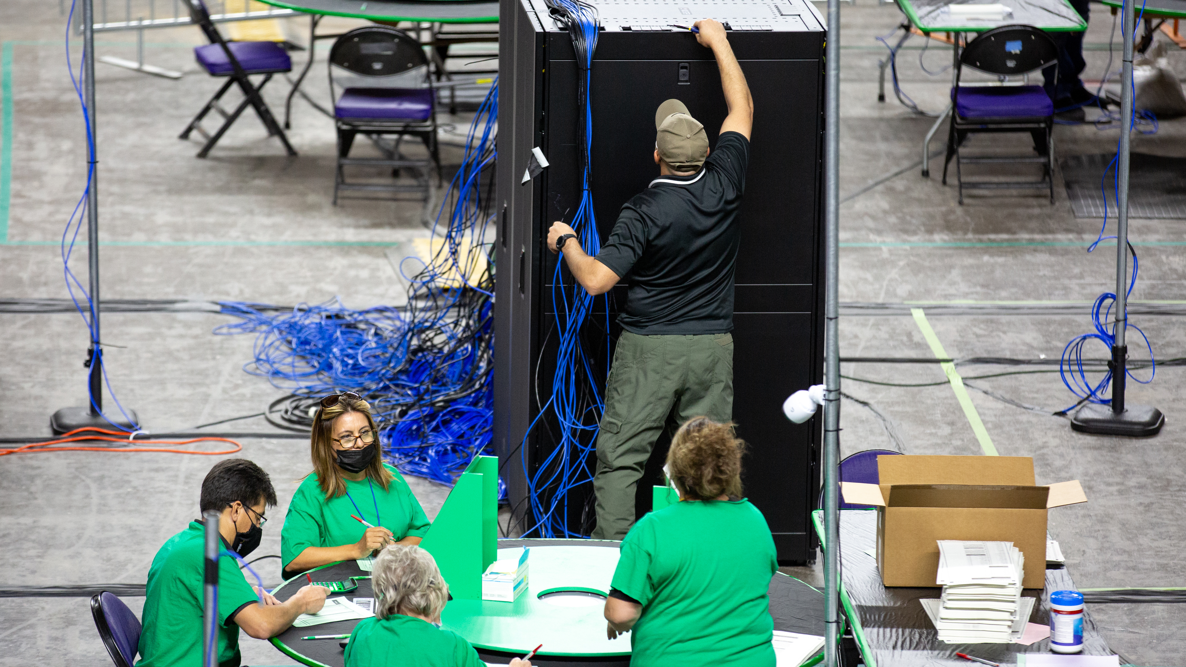 Contractors working for Cyber Ninjas, the company hired by the Republican-led Arizona state Senate, examine and recount ballots from the 2020 general election on May 3. Courtney Pedroza/The Washington Post via Getty Images