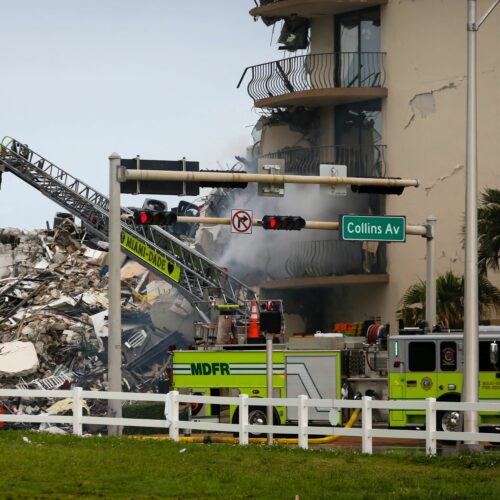 A Miami-Dade Fire Rescue truck is seen Thursday in front of debris from the partially collapsed Champlain Towers South complex in Surfside, Fla., north of Miami Beach. CREDIT: Eva Marie Uzcategui/AFP via Getty Images