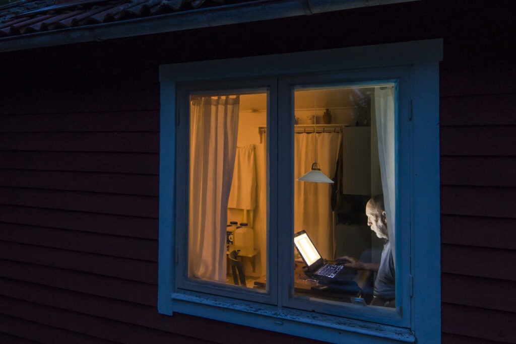 An older person sitting at a computer