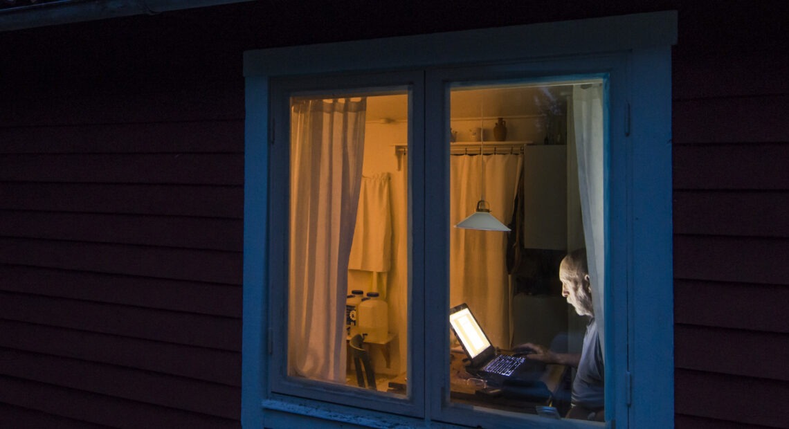 An older person sitting at a computer