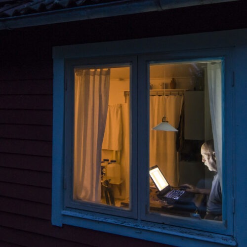 An older person sitting at a computer