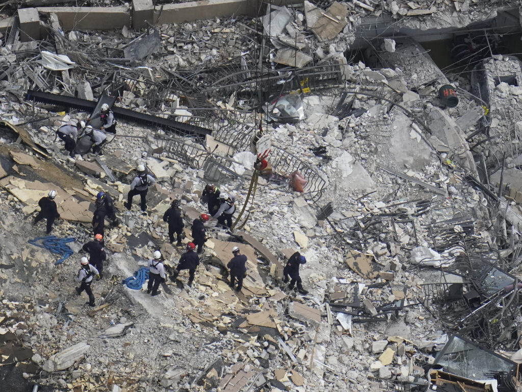 Rescue workers search in the rubble at the Champlain Towers South condo in Surfside, Fla., on June 26. CREDIT: Gerald Herbert/AP