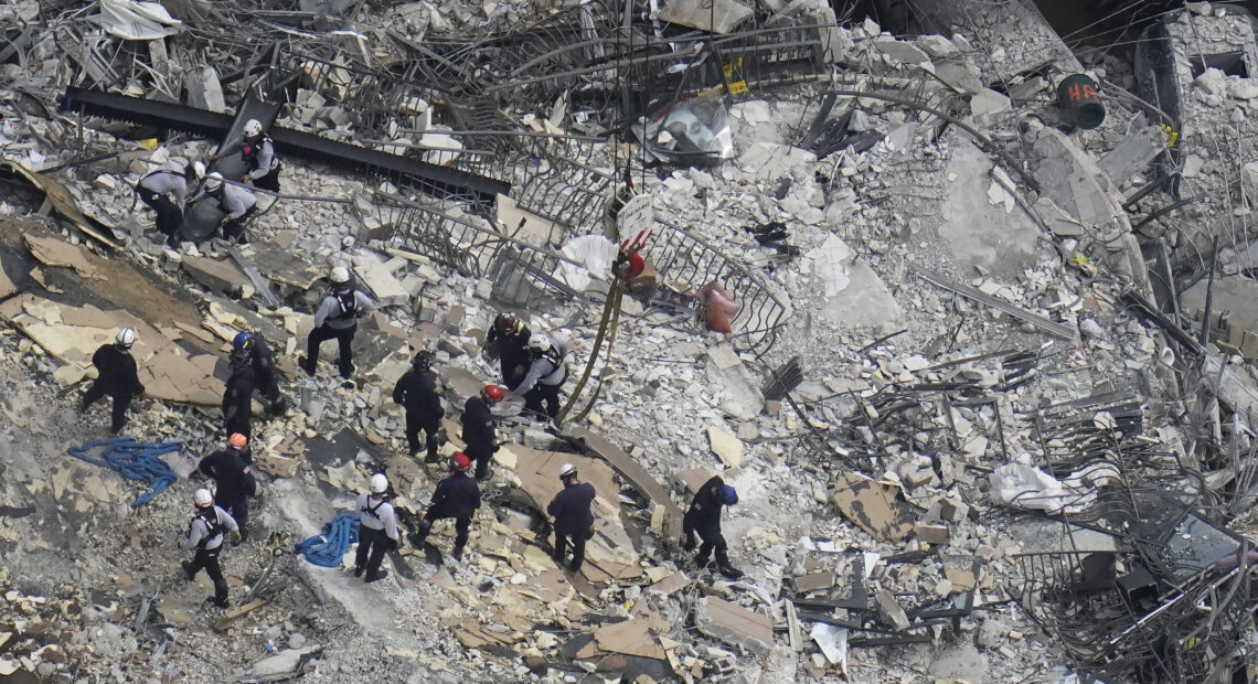 Rescue workers search in the rubble at the Champlain Towers South condo in Surfside, Fla., on June 26. CREDIT: Gerald Herbert/AP