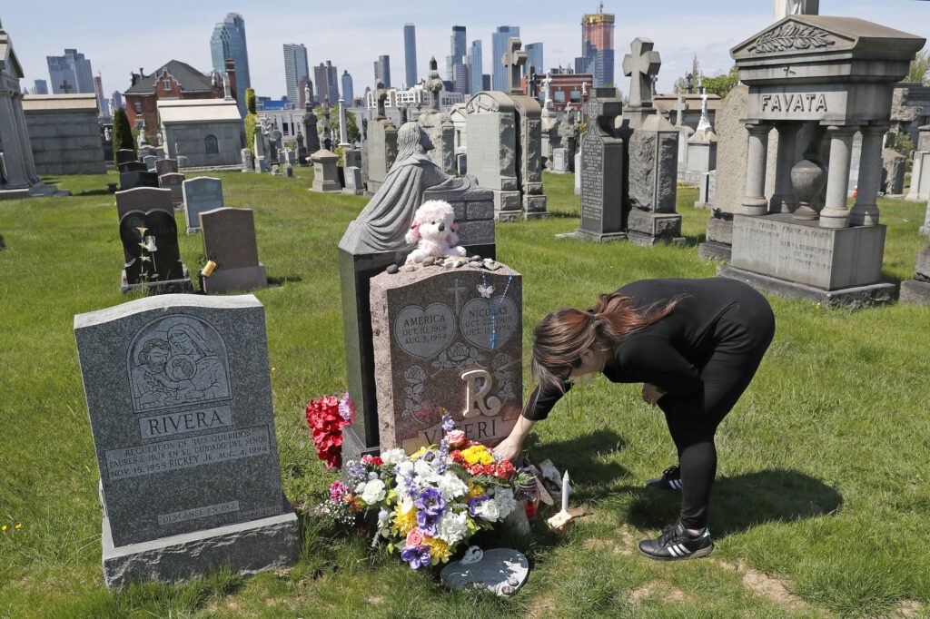 Sharon Rivera adjusts flowers at daughter Victoria's grave at Calvary Cemetery in New York City in 2020. Her daughter, 21, died of a drug overdose in 2019. According to new CDC data, drug overdose deaths soared to more than 93,000 last year. Kathy Willens/AP