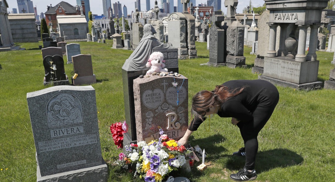 Sharon Rivera adjusts flowers at daughter Victoria's grave at Calvary Cemetery in New York City in 2020. Her daughter, 21, died of a drug overdose in 2019. According to new CDC data, drug overdose deaths soared to more than 93,000 last year. Kathy Willens/AP