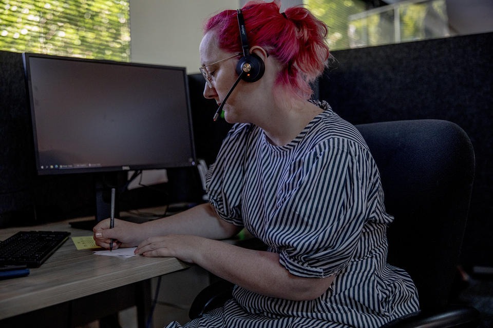 Crisis line phone volunteer Chessie Snider takes calls on June 29, 2021. Washington House Bill 1477 will provide money to improve staffing at the state’s crisis call centers and will also give call centers better tools to connect people to treatment options. CREDIT: Dorothy Edwards/Crosscut