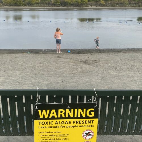 Warning sign in front of river