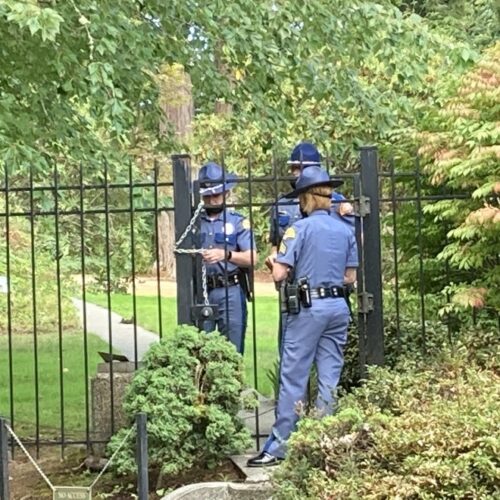 Washington State Patrol troopers use a chain to secure a gate at the governor's residence following a security breach on Wednesday, September 15, 2021.