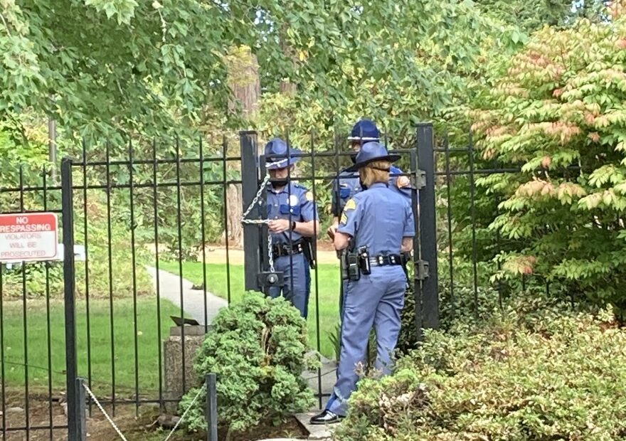 Washington State Patrol troopers use a chain to secure a gate at the governor's residence following a security breach on Wednesday, September 15, 2021.