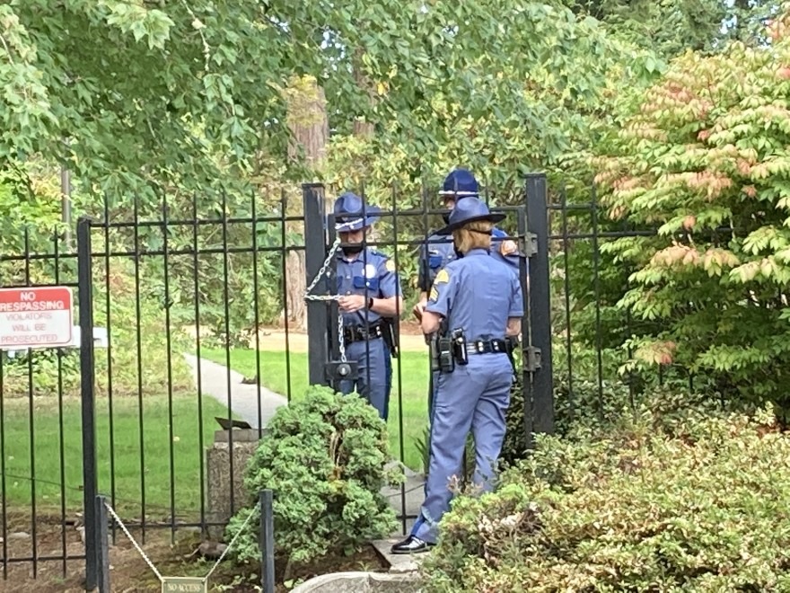 Washington State Patrol troopers use a chain to secure a gate at the governor's residence following a security breach on Wednesday, September 15, 2021.