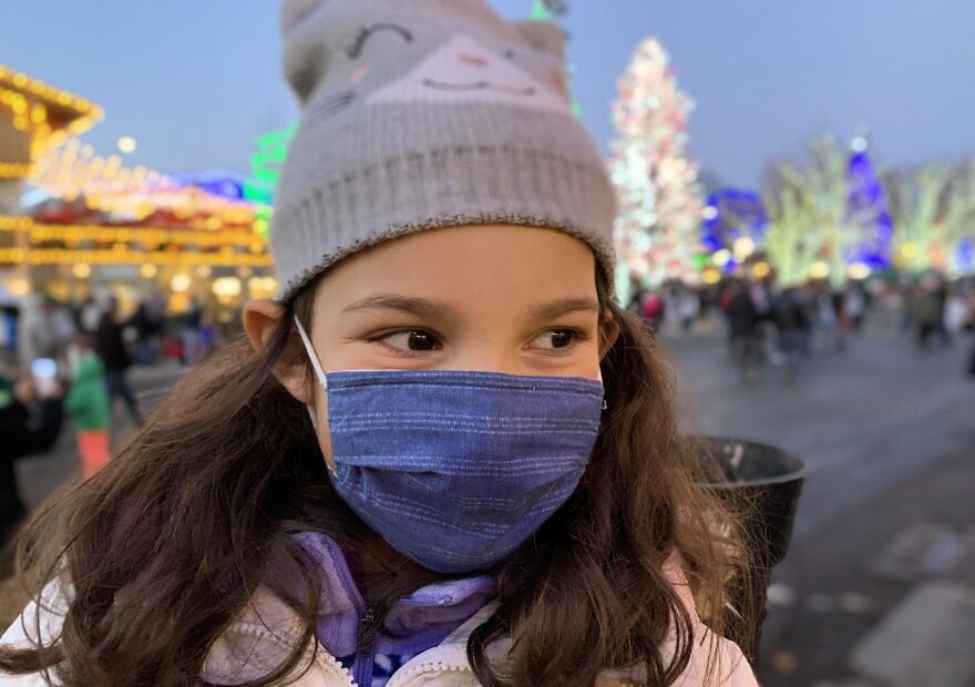 In this file photo from December 2020, a child wears a mask to protect from COVID-19 while attending a Christmas celebration in Leavenworth. Gov. Jay Inslee on Thursday announced he's expanding his statewide mask mandate to include large, outdoor events.