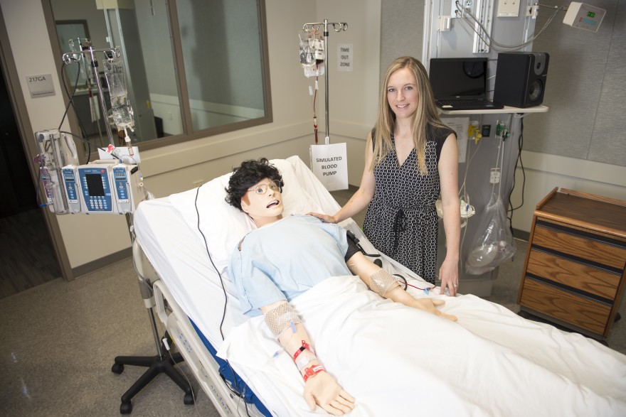 WSU Spokane College of Nursing assistant dean for research Lois James poses beside the lab mannequin that tired nurses interacted with in a recent study.