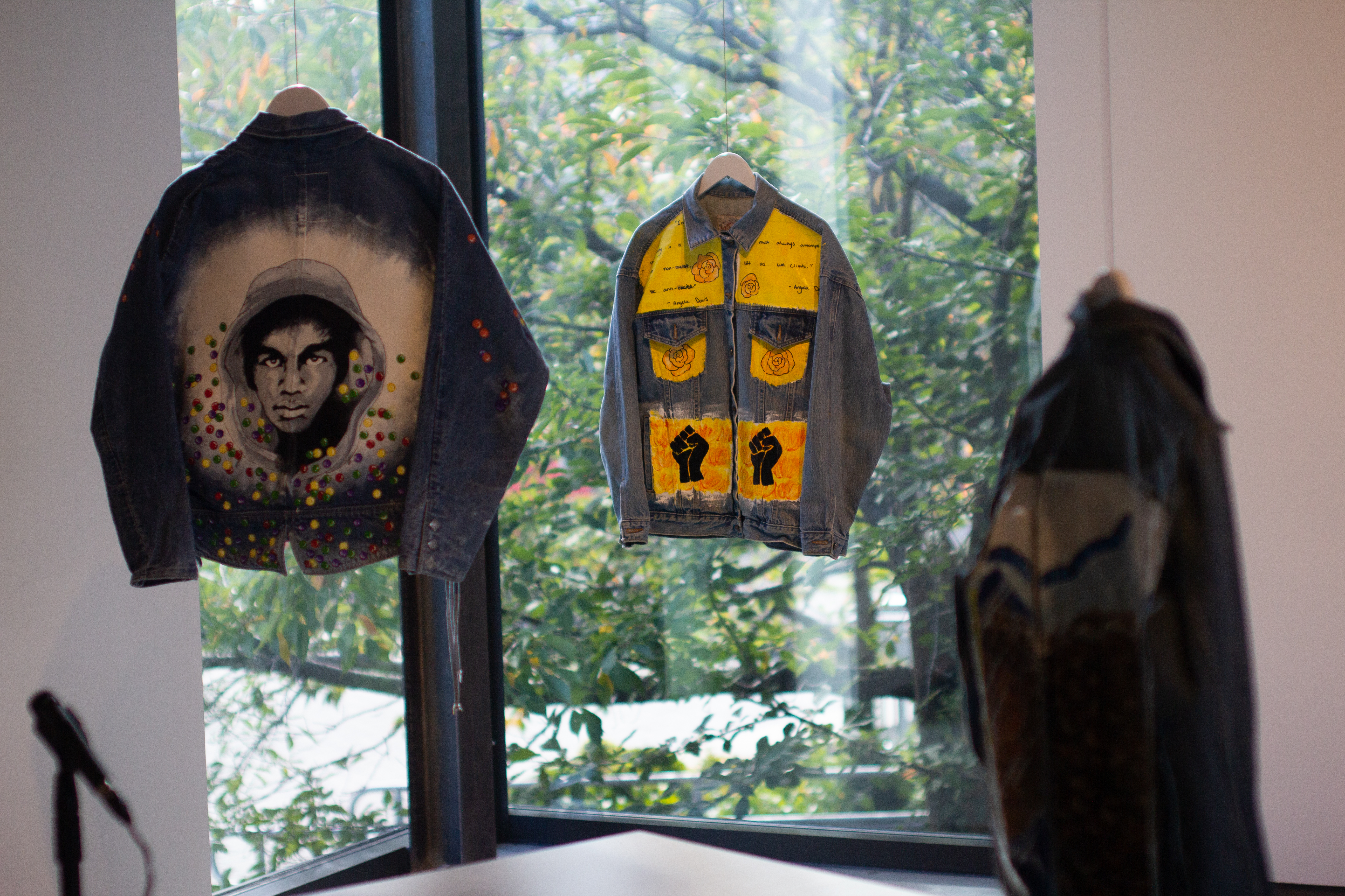 Painted denim jackets by Jackie Schaubel honors Trayvon Martin, who was murdered by a neighborhood watchman in 2012, and political activist and scholar Angela Davis.
