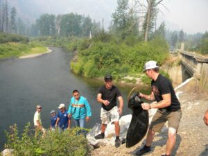 People help carry a salmon to the Sanpoil River at a release at Keller Park this August.