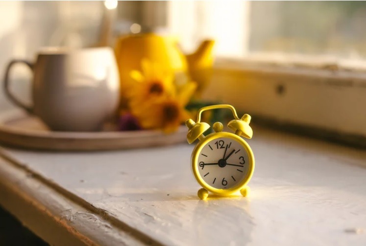 yellow clock on a white table. 