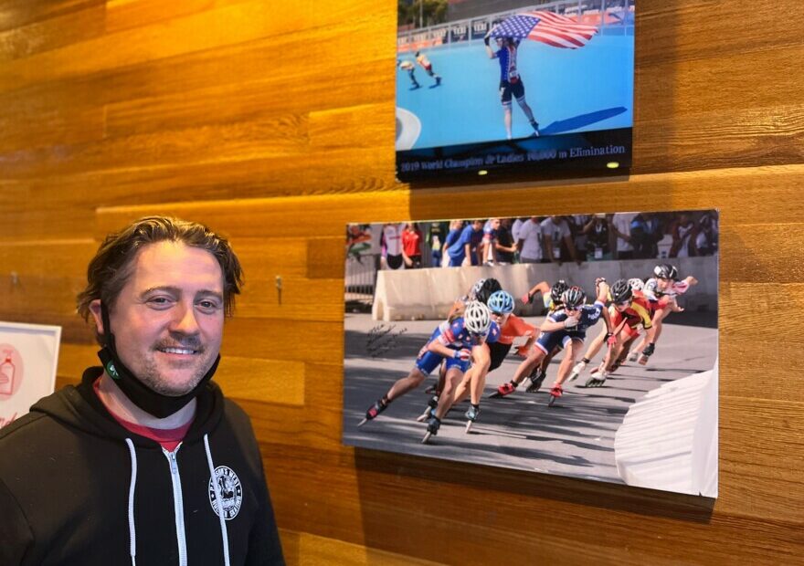 Inline skating coach Darin Pattison proudly stands beside some of the many photos of one of his proteges, Olympic short track speedskater Corinne Stoddard of Federal Way, WA, at the Pattison West roller rink in Stoddard’s hometown.