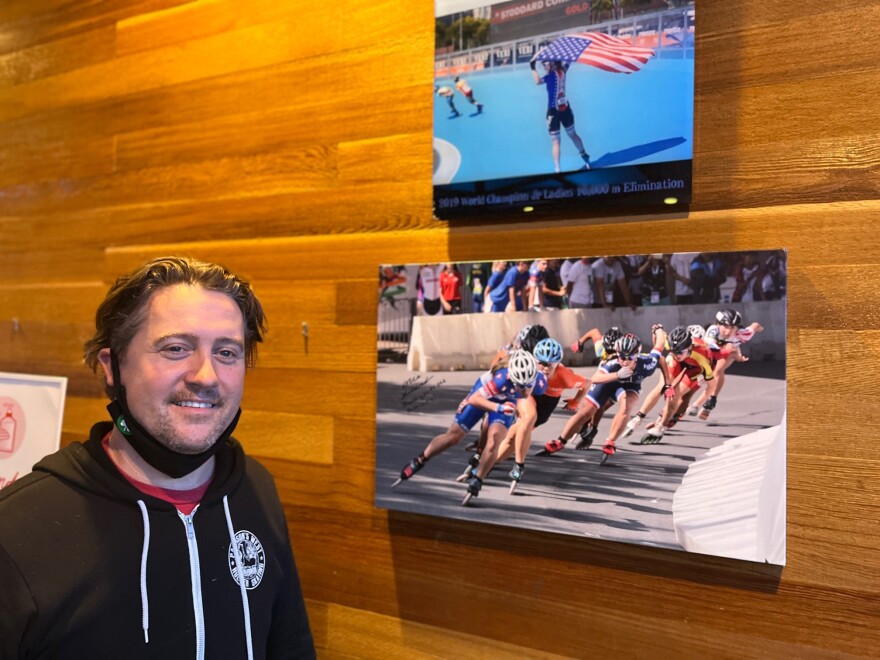 Inline skating coach Darin Pattison proudly stands beside some of the many photos of one of his proteges, Olympic short track speedskater Corinne Stoddard of Federal Way, WA, at the Pattison West roller rink in Stoddard’s hometown.