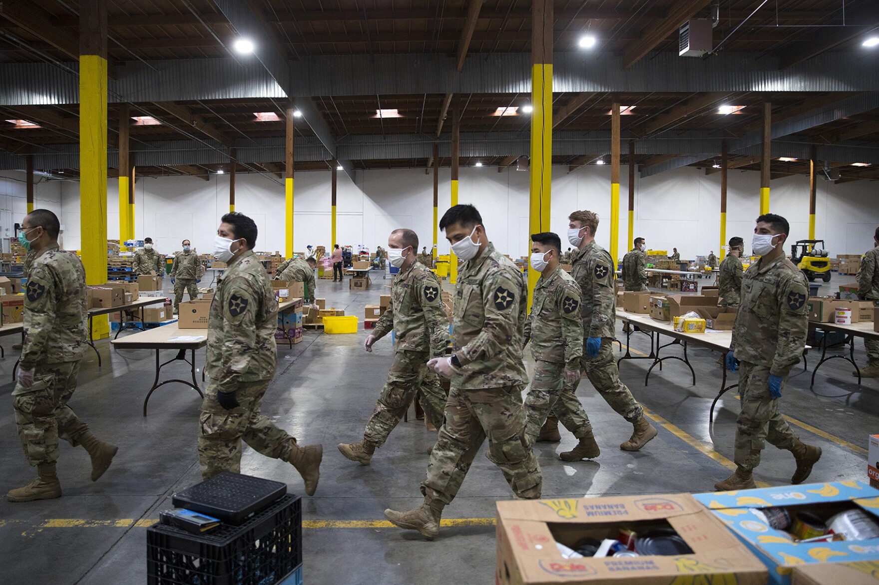 Washington National Guard soldiers walk through the Food Lifeline Covid Response Center on Tuesday, April 21, 2020, along East Marginal Way South in Seattle.