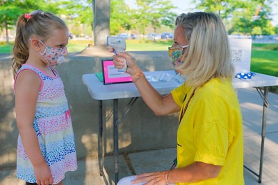 A woman takes a child's temperature