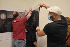 Bose and friends work to hang the photo display with wheat paste before the gallery show.