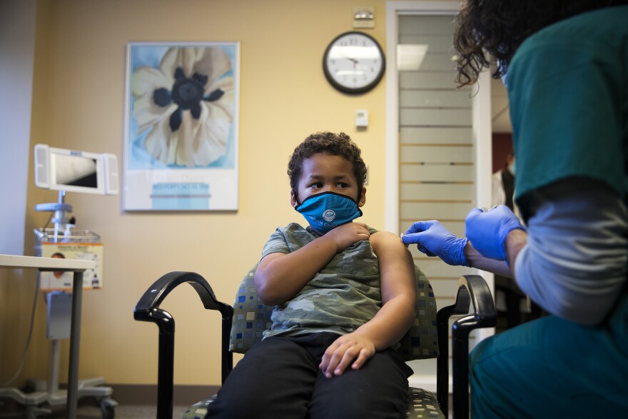 Isaac Williams, 6, wears a mask as he prepares to receive a dose of the Covid-19 vaccine on Tuesday, November 9, 2021, at Seattle Children's Hospital in Seattle. Wash. Gov. Inslee said on Feb. 9, 2022 that he’s lifting outdoor masking requirements.