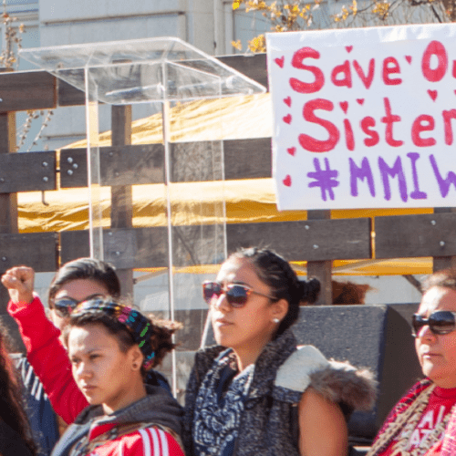 Protestors with arms raised bringing attention to plight of missing indigenous women.