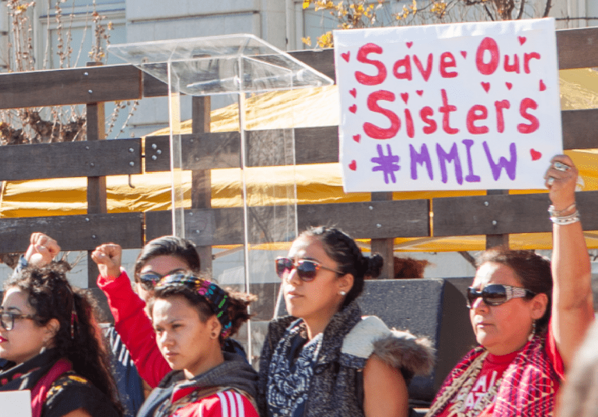 Protestors with arms raised bringing attention to plight of missing indigenous women.