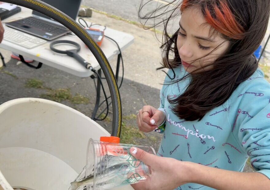 During the 2022 Salmon Summit, Jennasys Alaniz, 10, a fourth grade student at Cascade Elementary School in Kennewick, releases a newly tagged young salmon into the Columbia River.