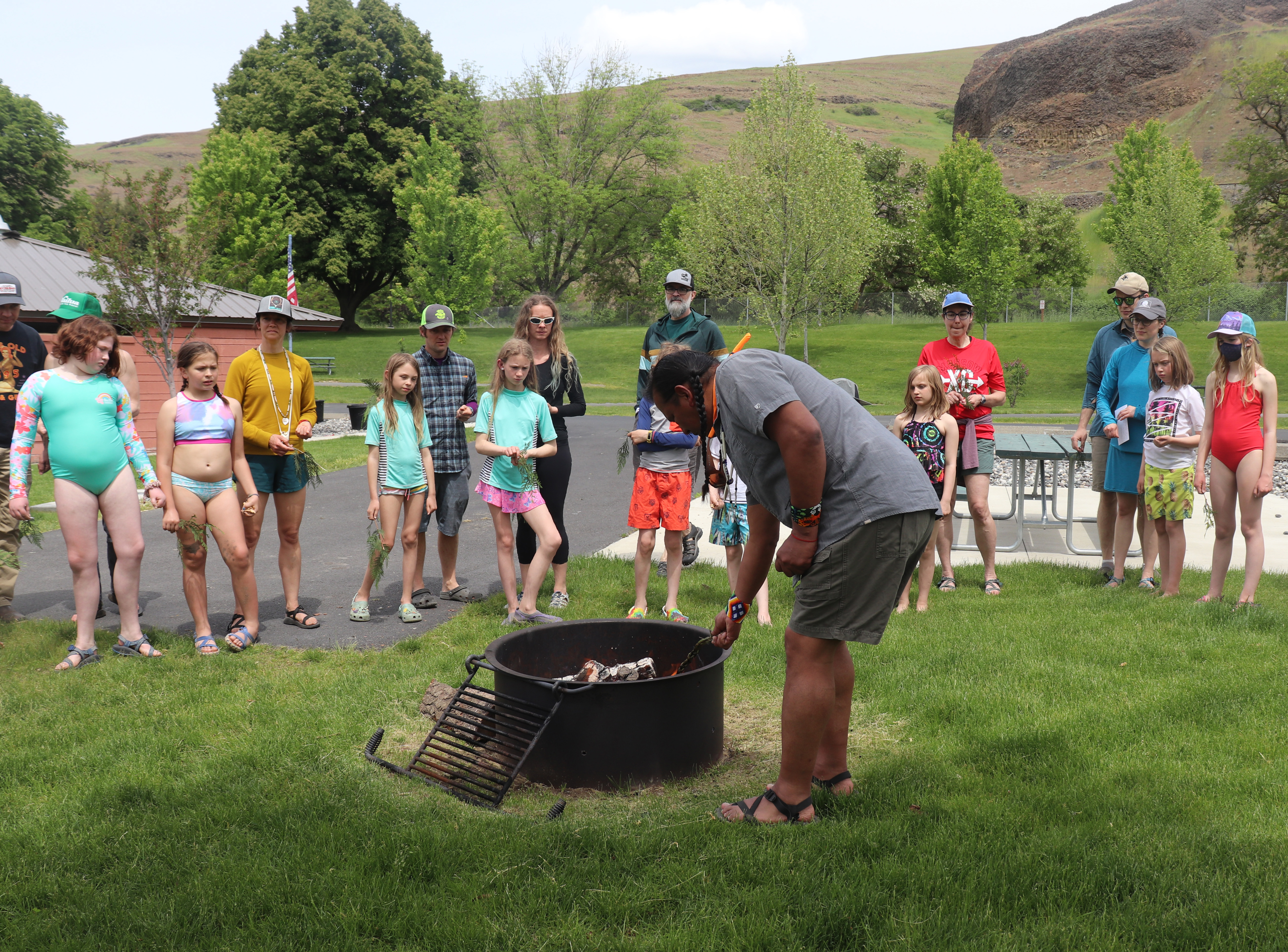 Gary Dorr, 55, lights a sprig of cedar on fire during a ceremony as students, parents and volunteers watch