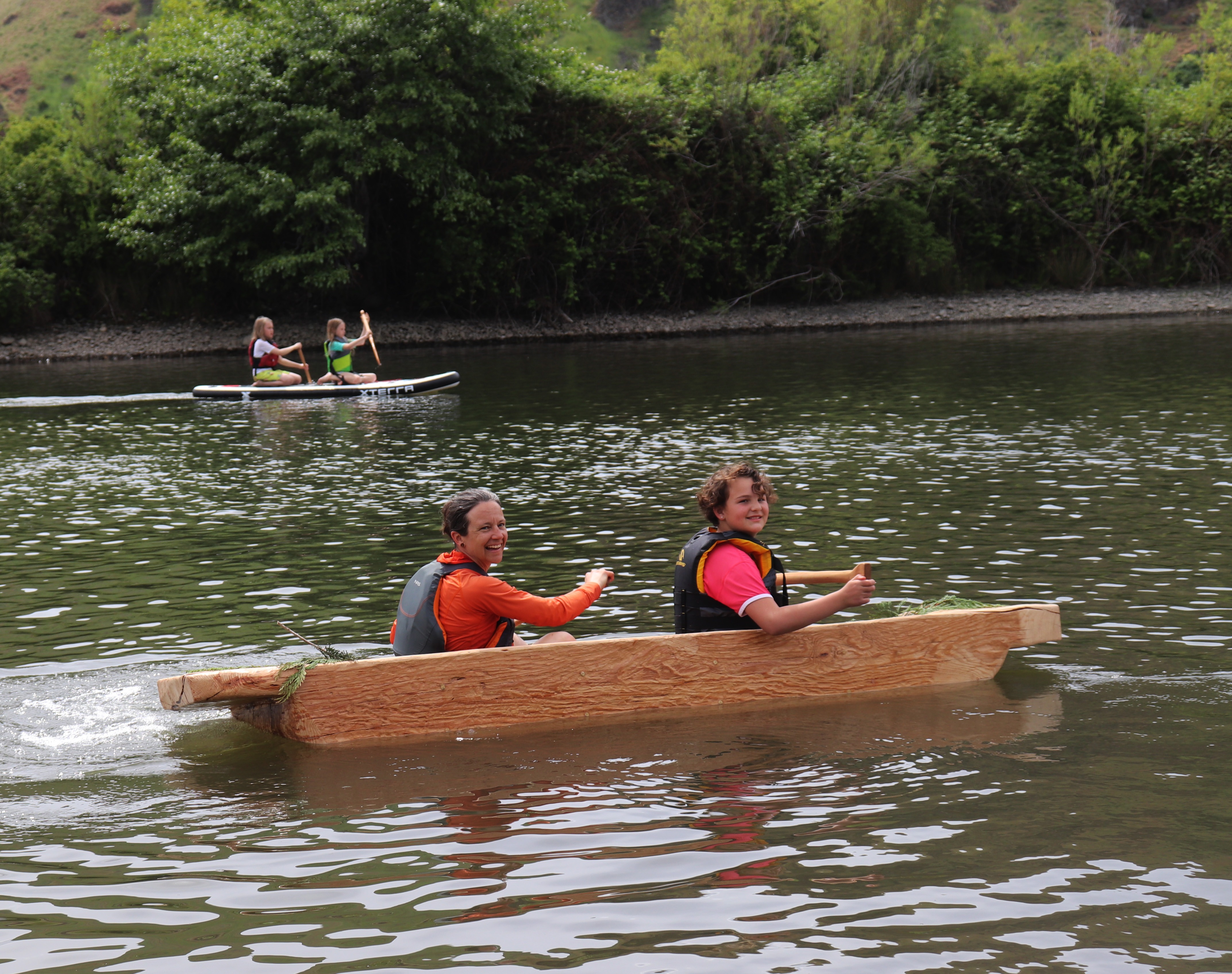 Lauren Venzke and Renée Hill row across the water in a dugout canoe.