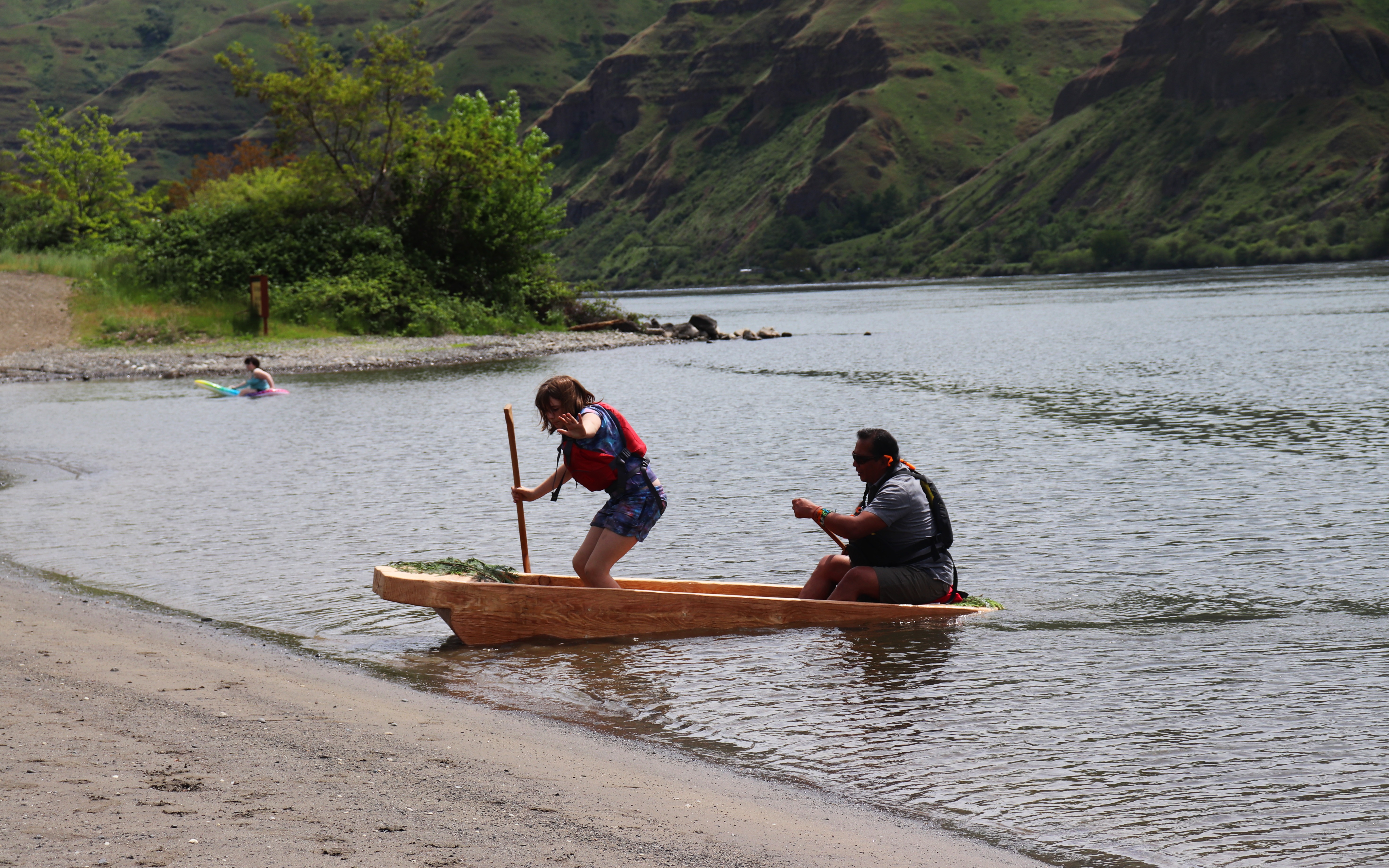 Josie Tate and Gary Dorr row across the water in a dugout canoe