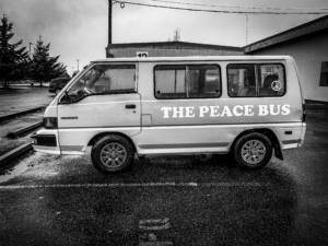 A black and white image of a Mitsubishi van sitting in a parking lot. The words 