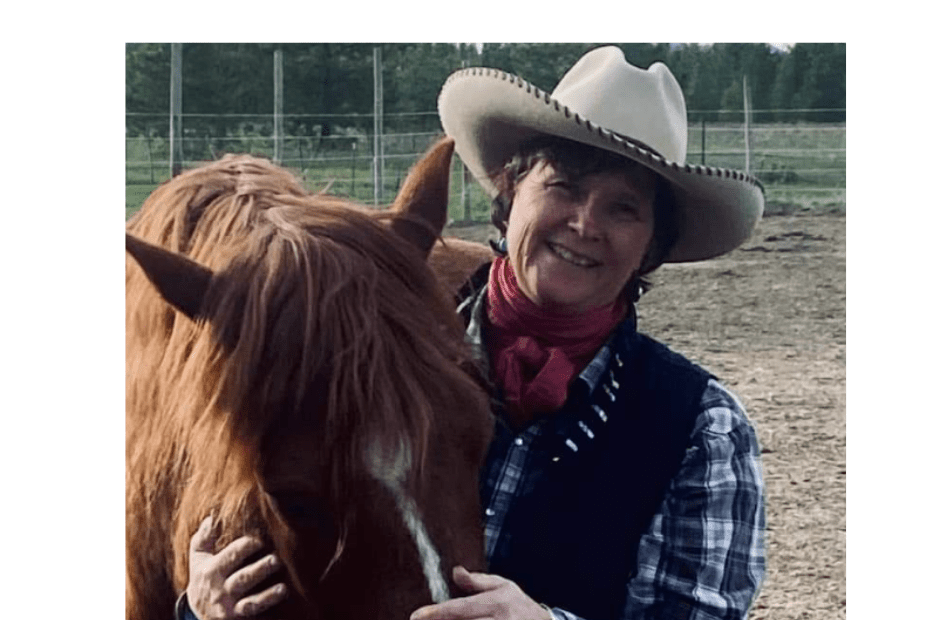 Woman holding nose of a happy horse.