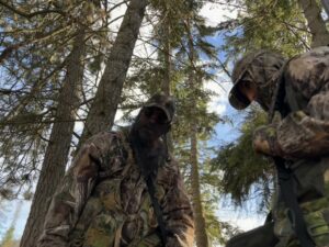 Aaron Garcia, a hunter education and volunteer coordinator for the Washington Department of Fish and Wildlife, helps new hunter Keely Hopkins search for signs of wild turkey in northeastern Washington.