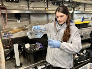 Rebecca Smoak, a graduate research at Oregon State University, sets up a dilution experiment on the Bell M. Shimada, a NOAA research vessel.