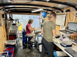 Scientists Jill Janak (right) and Kate Deters collect information and tag juvenile lamprey inside a trailer at Lower Granite Dam.