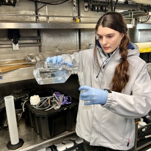 Rebecca Smoak, a graduate research at Oregon State University, sets up a dilution experiment on the Bell M. Shimada, a NOAA research vessel