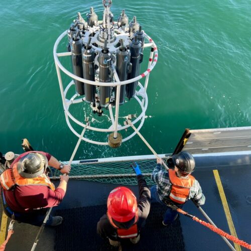 The deck crew on NOAA's Bell M. Shimada hauls the CTD machine back on deck after it collected water samples from the ocean